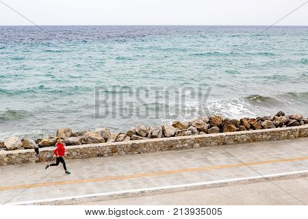 Woman Jogging On City Street At Seaside