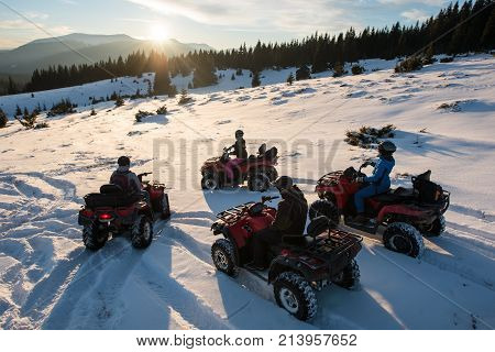 Group Of People Sitting On Off-road Quad Bikes, Enjoying Beautiful Sunset In The The Mountains In Wi