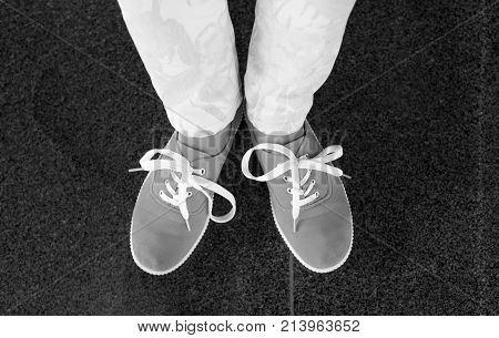 Pink sneakers with yellow shoes lace on girl young woman legs outdoors on black marvel flloor
