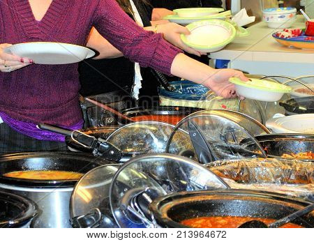 Pasta potluck dinner served inside a kitchen hall.