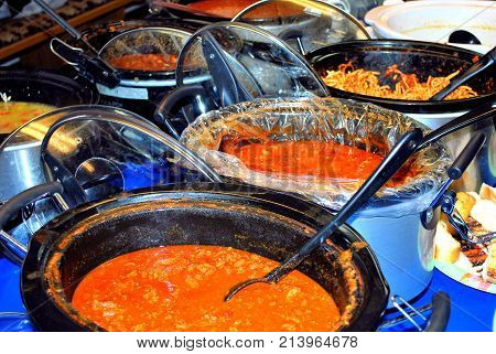 Pasta potluck dinner served inside a kitchen hall.