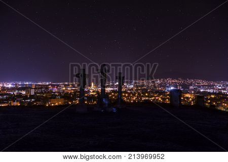 City night in Nitra from the view point on top of Hill (mountain) Slovak city Nitra with purole night sky and crosses. City center at night with buildings and churches. City at night with stars