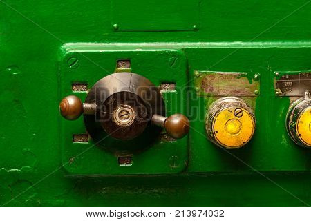 part of an old milling machine with levers green background with yellow circles