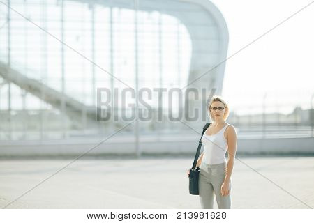 The image of a business woman standing on the street at sunset