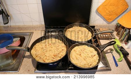 Three Big Pans With The Food Named Frico A Typical Italian Recip
