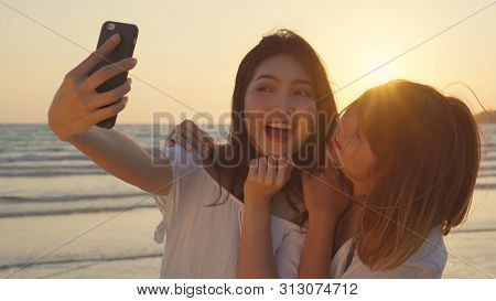 Young Asian Lesbian Couple Using Smartphone Taking Selfie Near Beach. Beautiful Women Lgbt Couple Ha