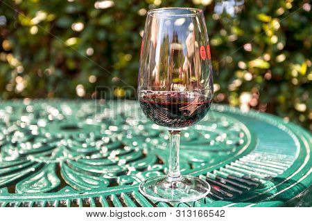 Porto, Portugal: Red Wine On Patterned Table At Outddor Cafe In Green Garden On 21 May, 2019. Portug