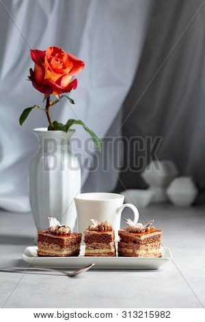 Layered Cakes With Rose On A White Marmorean Table.