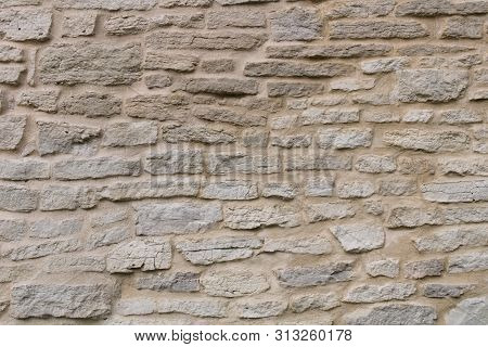 The Texture Of The Fortress Wall Of Hand-crafted Bricks Of Gray Limestone. Historical Stonework Of T