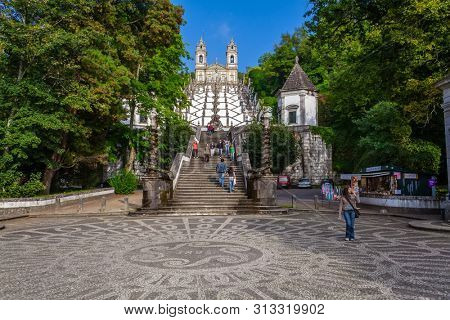 Braga, Portugal - October 6, 2017: Bom Jesus do Monte Sanctuary Basilica on top with Staircase of Five Senses and Staircase of Virtues on foreground. Cobblestone ornate pavement
