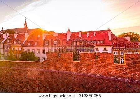 Warsaw, Poland Sunset View Of Barbican Or Barbakan Wall And Old Town Houses