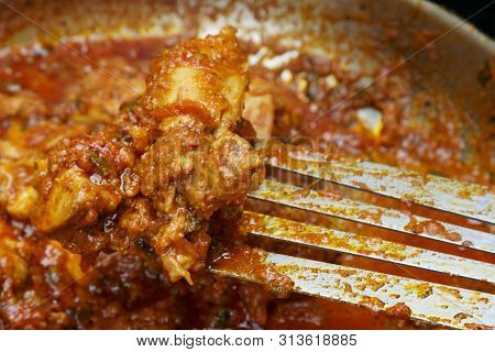 Stirring And Cooking Tava Chicken Outdoors In A Pan On Coals.