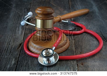 Legal Regulation Of Medicine, Law Concept, Judges Gavel And Stethoscope On Wooden Background.