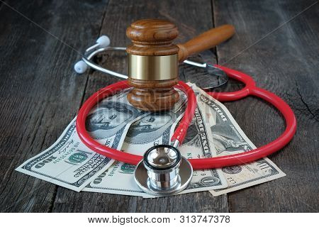 Legal Regulation Of Medicine, Law Concept, Judges Gavel, Stethoscope And Us Dollars On Wooden Backgr