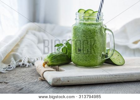Photo Of Green Cucumber Smoothie In Jar With Straw On Light Background. Fresh Organic Smoothie. Heal