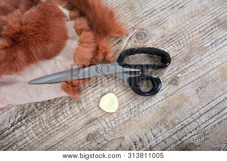 Brown Rabbit Fur For Sewing, Scissors And Chalk On Wooden Background.