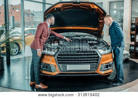 Man Exploring The Car Under The Capote.