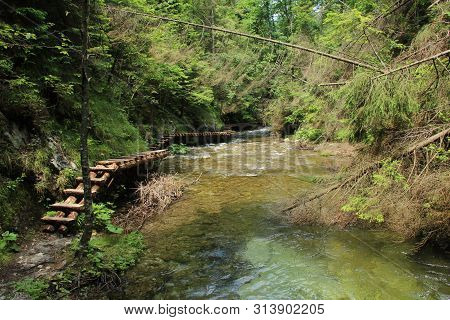 A Wooden Footbridge Running Along A Larger Stream In The Slovak Paradise National Park