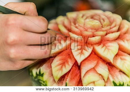 Close Up Crafts Carved Watermelon With The Hand And Carving Knife