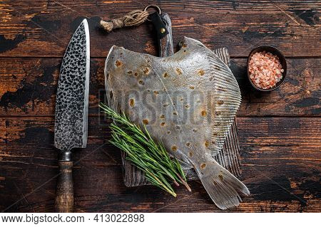 Raw Plaice Flatfish Fish On Butcher Board With Knife. Dark Wooden Background. Top View