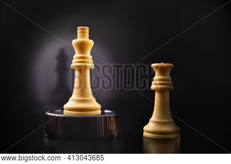 Concept Of Airs Of Superiority Of Man Against Woman With Chess King Token Raised On A Podium And Que