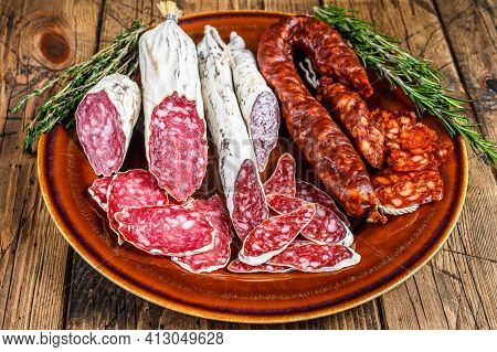 Spanish Charcuterie With Sliced Sausages Salami, Fuet And Chorizo On A Rustic Plate. Wooden Backgrou