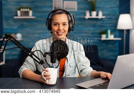 Portrait Of Smiling Blogger Looking At Camera Before Starting Live Video At Home Studio Podcast Hold