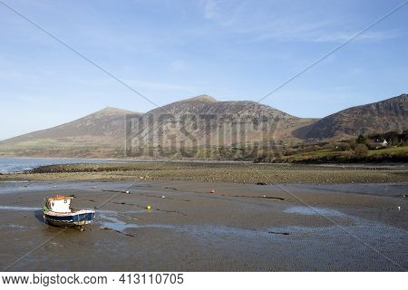 Trefor North Wales. Landscape With Beach On Sunny Spring Day.  Solitary Small Fishing Boat On The Sa