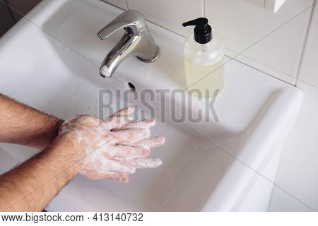 Washing Hands Concept. Man Cleaning His Hands Using Liquid Disinfectant Soap And Water In Bathroom, 