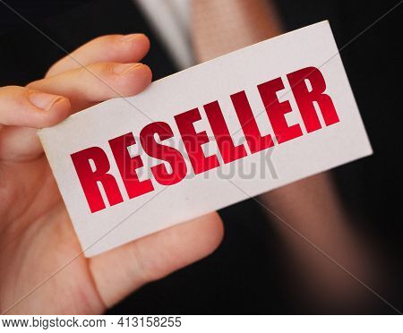 Businessman Holding A Card With Reseller Word. Reselling Business Concept.
