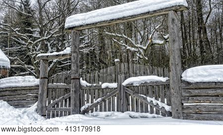 Snowy Old Garden Gate In Village Courtyyard. Snowy Wooden Gate After A Blizzard. Winter Background.