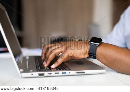 Side Profile Cropped Photo Of Afro Successful Businessman Hands With Fitness Watch, Typing On Keyboa