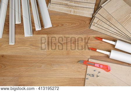 Set Of Items For Pvc Ceiling Indoor Works. Assembly Adhesive Bottles And Pvc Panels With Plastic Cor