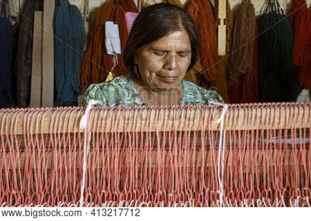 Oaxaca, Mexico - 2019-11-30 - Woman Works At Her Loom Making A New Blanket.