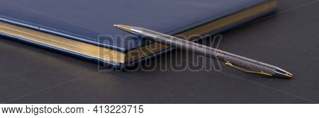 Blue Diary And Pen On A Black Background. Planning. Business Concept
