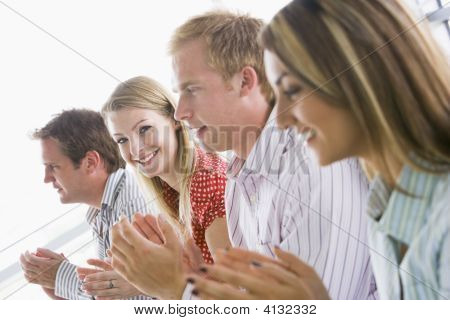 Four Businesspeople Applauding Indoors Smiling