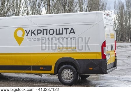 White And Yellow Postal Van On Rainy City Street. Freight Transport Of The Ukrposhta Company. Inscri