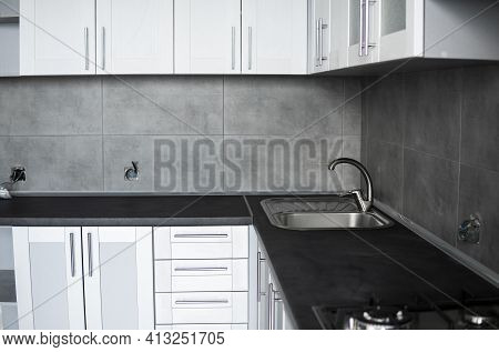 Modern Minimalism Style Kitchen Interior In Monochrome Tones. Custom Kitchen With Grey White Facades