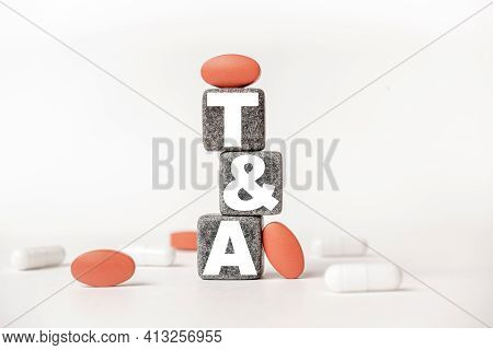 A Group Of White And Red Pills And Cubes With The Word Ta Tonsillectomy And Adenoidectomy On Them, W