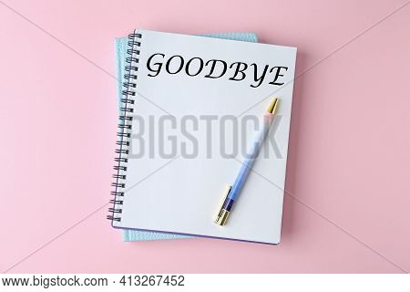 Notebook With Word Goodbye On Pink Background, Top View