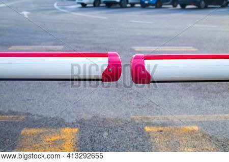 Closed Barrier On Carpark. Two White And Red Staves And Asphalt With White And Yellow Road Markings.