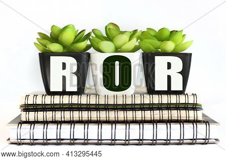 Ror. Text On Pots Of Plants That Stand On Notepads On White Background
