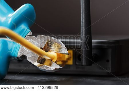 Tearing And Cutting With Blue Wire Cutters The Network Connection Of The Yellow Wire Of The Internet