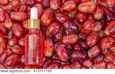 Grape Seed Oil In A Bottle, Lies On The Berries Of Red, Fresh, Juicy Grapes.