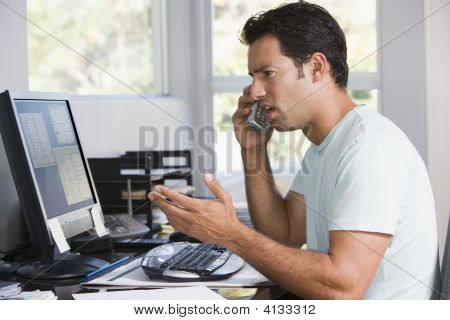 Mand i Home Office på telefon ved hjælp af Computer og rynker