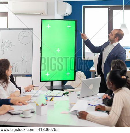 Leader Of Company Presenting Financial Plan Using Mockup Display In Front Of Diverse Team Brainstorm