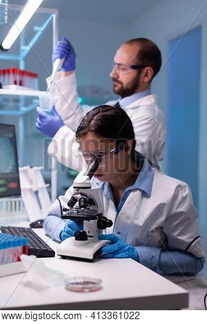 Chemist Researchers Working In Laboratory With Micropipette And Microscope. Modern Lab For Scientifi
