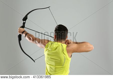 Man With Bow And Arrow Practicing Archery On Light Grey Background, Back View