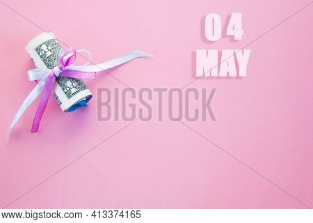 Calendar Date On Pink Background With Rolled Up Dollar Bills Pinned By Pink And Blue Ribbon With Cop