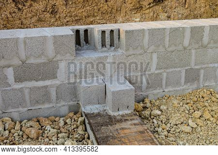 Construction Of Stone Walls Of A Building From Hollow Concrete Blocks On Heavy Granite Gravel. Mason